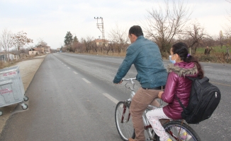Fedakar baba, yürüyemeyen kızını okula bisikletiyle götürüyor